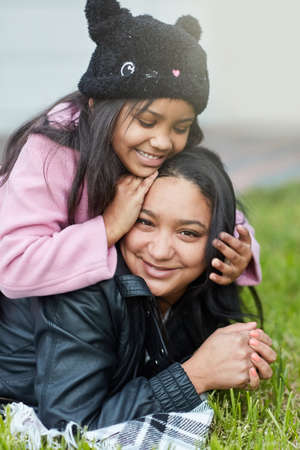 She loves to play with mommys hair. Cropped shot of a little girl playing with her mothers hair outside.の写真素材