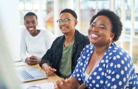 A positivity inspiring project management process. Shot of a group of young businesspeople having a meeting in a modern office.の写真素材