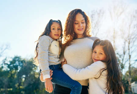 Mothers and daughters always have a special bond. Cropped shot of a beautiful young mother and her adorable daughters outdoors.の写真素材