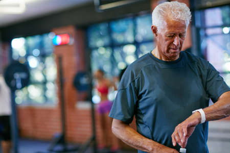 Right on time. Cropped shot of a senior man working out in the gym.の写真素材