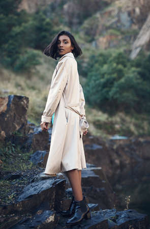 The world is full of beautiful things, like you. Shot of a fashionable young woman posing against a nature background.の写真素材