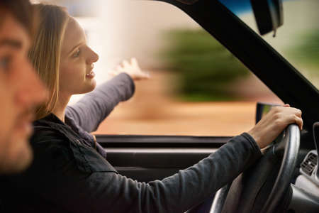 Happiness is a journey, not a destination. A happy young couple in their car enjoying a road trip.