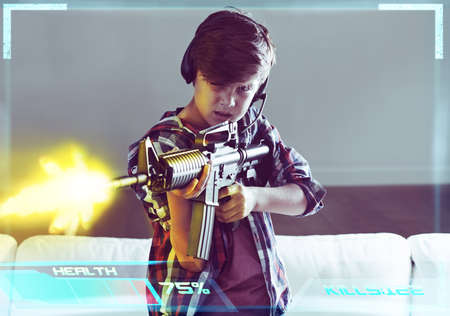Call of duty. Shot of a young boy playing violent video games.の写真素材