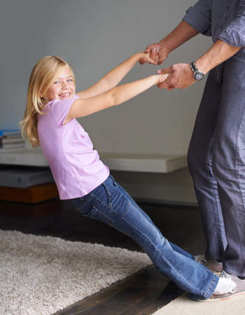 Family bonding. Shot of a little girl and her father at home.の写真素材