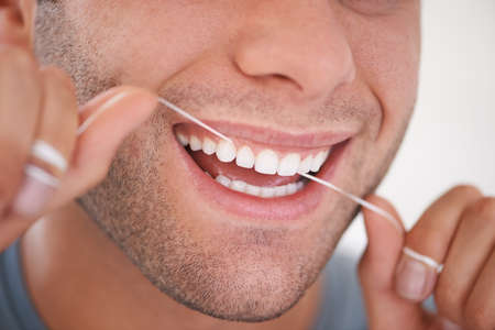 Oral hygiene. Cropped shot of a man flossing his teeth.の写真素材
