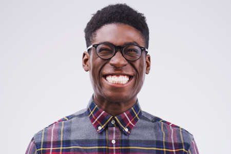 Lifes better when youre smiling. Studio shot of a young man making a funny face against a gray...