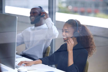 Well answer you call. Shot of a young businesswoman working in a call centre.