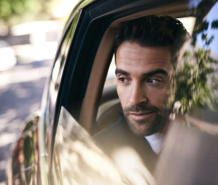 Pulling up to the office in style. Cropped shot of a handsome young businessman on his morning...