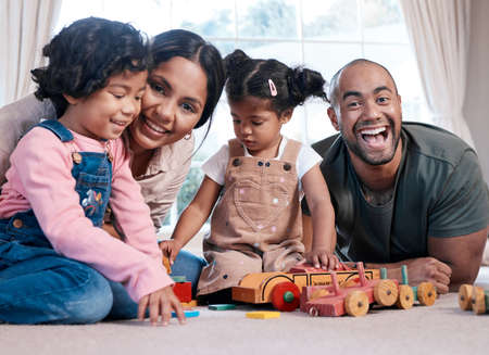 Theres joy in just being together. Portrait of a happy family playing together with wooden toys at...