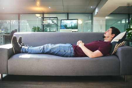 The subconscious holds the answers to lifes questions. Shot of a young man lying down on a sofa in a...