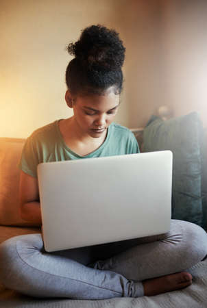 Going through some online study material. Cropped shot of a young female student studying at home.