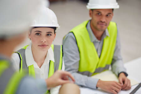 Listening to their superior. High angle shot of two young construction workers listening to a...