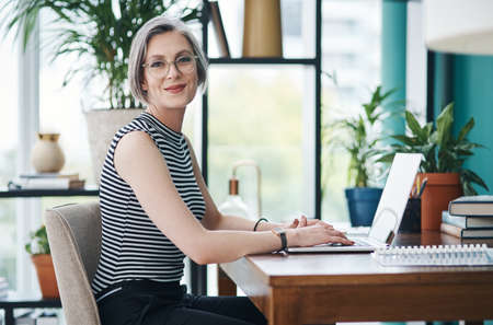 The only thing thatll get you to the top is hard work. Cropped shot of a mature businesswoman sitting in a modern office.の写真素材