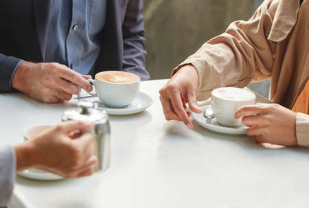Give me your best shot. Shot of a group of coworkers having a meeting at a coffee shop.の写真素材