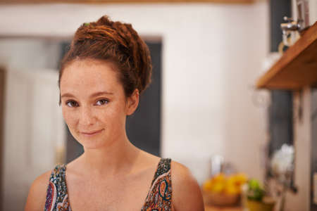 Shes got alternative style. Portrait of a young woman with dreadlocks standing in her home.