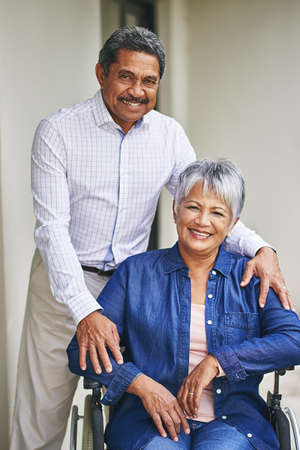 Were taking the road to recovery together. Portrait of a senior man pushing his wife in a wheelchair...