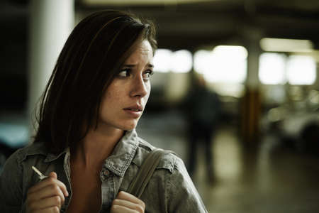 Something doesnt feel right.... A young woman in a parking lot looking concerned as someone follows...