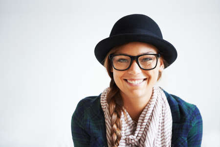 Young, trendy and and confident. A young woman smiling at the camera against a white background.の写真素材