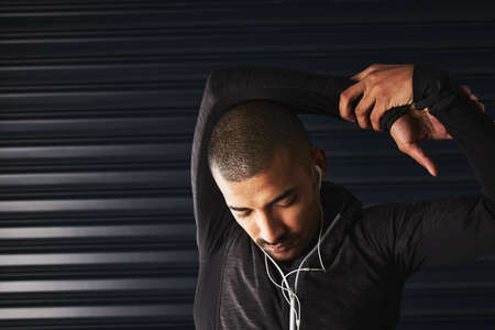 Warming up is his meditation. Shot of an athletic young man warming up before his workout in the...