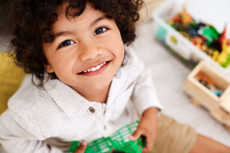 Playtime is my favorite time of the day. Portrait of an adorable little boy sitting on the floor and...