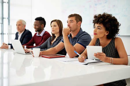 This presentation has got them thinking. Cropped shot of a group of businesspeople listening to a...