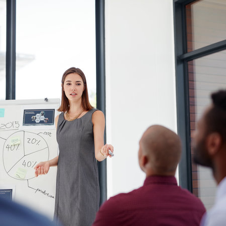 Leading the project with confidence. Shot of a group of colleagues having a presentation at work.の写真素材