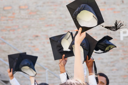 Time to throw those hats in the air. Shot of a group of students throwing their caps into the air on graduation day.の写真素材