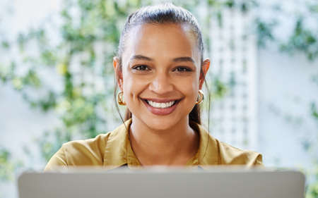 I love working at home. Cropped portrait of an attractive young woman businesswoman working on her laptop at home.の写真素材