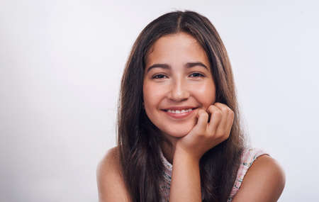Confidence is the new beautiful. Cropped portrait of an attractive teenage girl standing alone against a white background in the studio.の写真素材