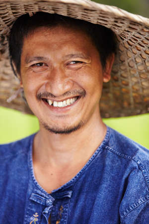 Closeup portrait of a Thai rice paddy worker wearing a traditional hat. Closeup portrait of a Thai rice paddy worker wearing a traditional hat.の写真素材