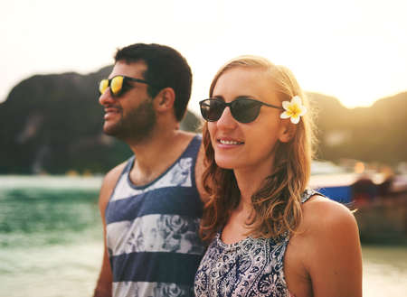 This is the perfect getaway. Cropped shot of a young couple enjoying a day at the beach together.の写真素材