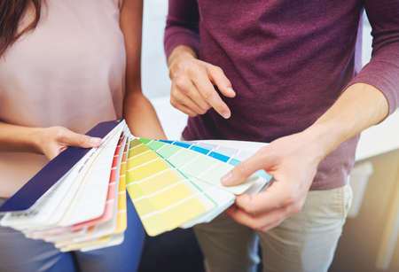 Finding the perfect color. Cropped shot of two unrecognizable designers looking at a color swatch.の写真素材