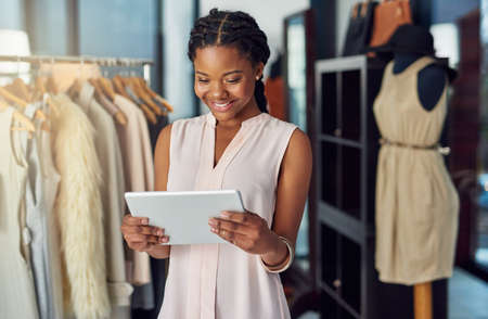 Embarking on her big business venture. Cropped shot of a young business owner using a digital tablet in her shop.の写真素材