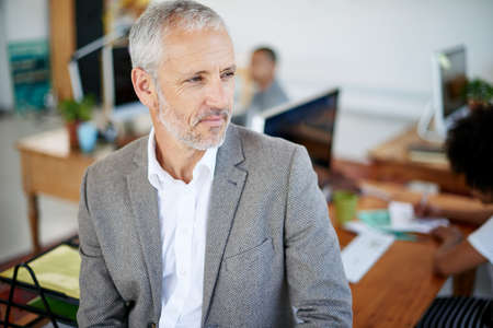 Hes got another great idea just waiting to be unleashed. Shot of a mature businessman standing in an...