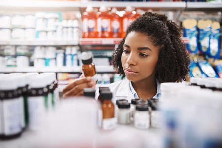 This one should do the trick. Cropped shot of an attractive young female pharmacist working in a pharmacy.の写真素材
