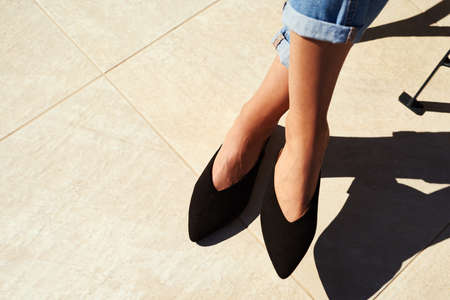 Keeping up with trends. Cropped shot of an unrecognizable businesswoman sitting alone and crossing...
