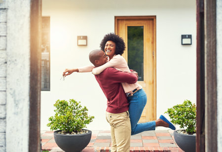 Finally a home of our own. Shot of a young couple celebrating the move into their new house.の写真素材