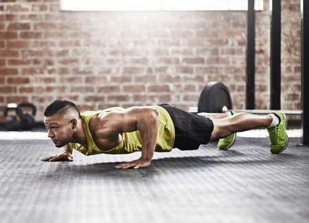 Putting everything into his training session. Full length shot of a young man working out in the...