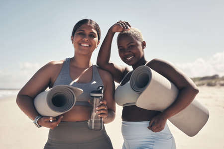 Friends who sweat together, stick together. Shot of two young women holding their yoga mats while on...