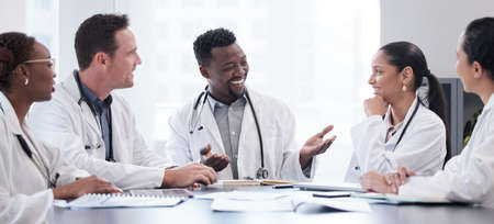 A meeting of medical minds. Cropped shot of a group of young doctors having a meeting around a table...
