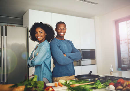 We make the best team. Portrait of a cheerful young couple standing together over a table full of...