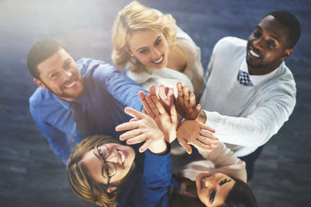 This team is going to the top. High angle shot of a group of businesspeople reaching for a high...