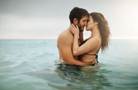 Loving in the middle of nowhere. Shot of an affectionate couple spending some time in the water.