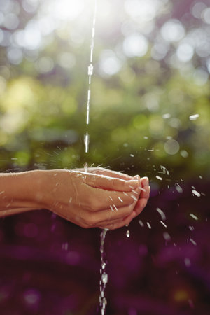 Water and life are one. Cropped shot of a woman washing her hands outdoors.の写真素材