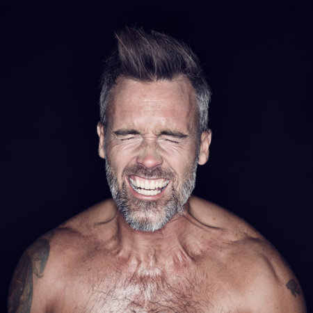 Letting it all out. Portrait of mature man posing against a dark background.の写真素材