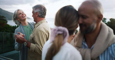 The skies may change but real love stays the same. Shot of two happy couples dancing outdoors.の写真素材