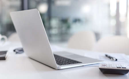 Technology will help you figure it all out. Closeup shot of a laptop and calculator on a desk in an...