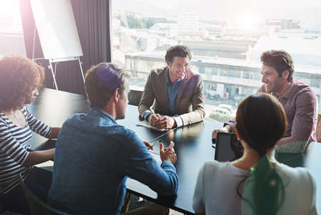 Wrapping their heads around the project. Shot of a group of coworkers having a brainstorming session in an office boardroom.の写真素材