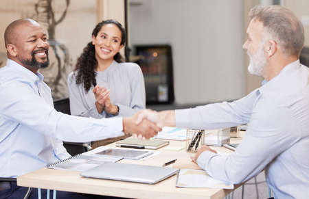 Coming to an agreement. Cropped shot of two handsome mature businessmen shaking hands while sitting...