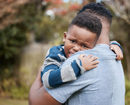 Shh, theres no need to cry. Shot of an unrecognisable father comforting his son while bonding with him in the garden.の写真素材